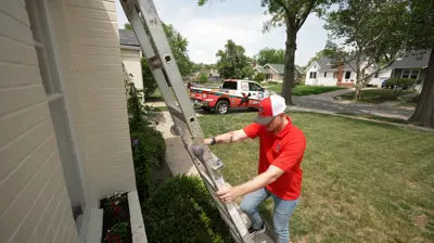 Mighty Dog Roofing technician setting up a ladder for a roof inspection at a suburban home in Sarasota. A branded Mighty Dog truck is parked nearby.