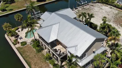 New metal roofing installed on a Florida home, showing clean lines and hurricane-ready materials in a residential neighborhood.
