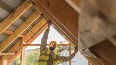 man working on the underside of a roof structure