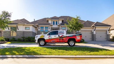 Mighty Dog Roofing truck parked by a property with new roof