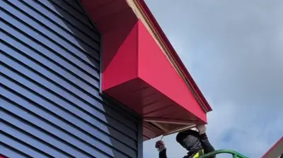 Regal Red standing seam metal roof and Midnight Blue siding on a North Providence RI commercial building.