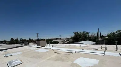 Professional roof restoration work showing repairs and surface preparation before applying a roof coating.