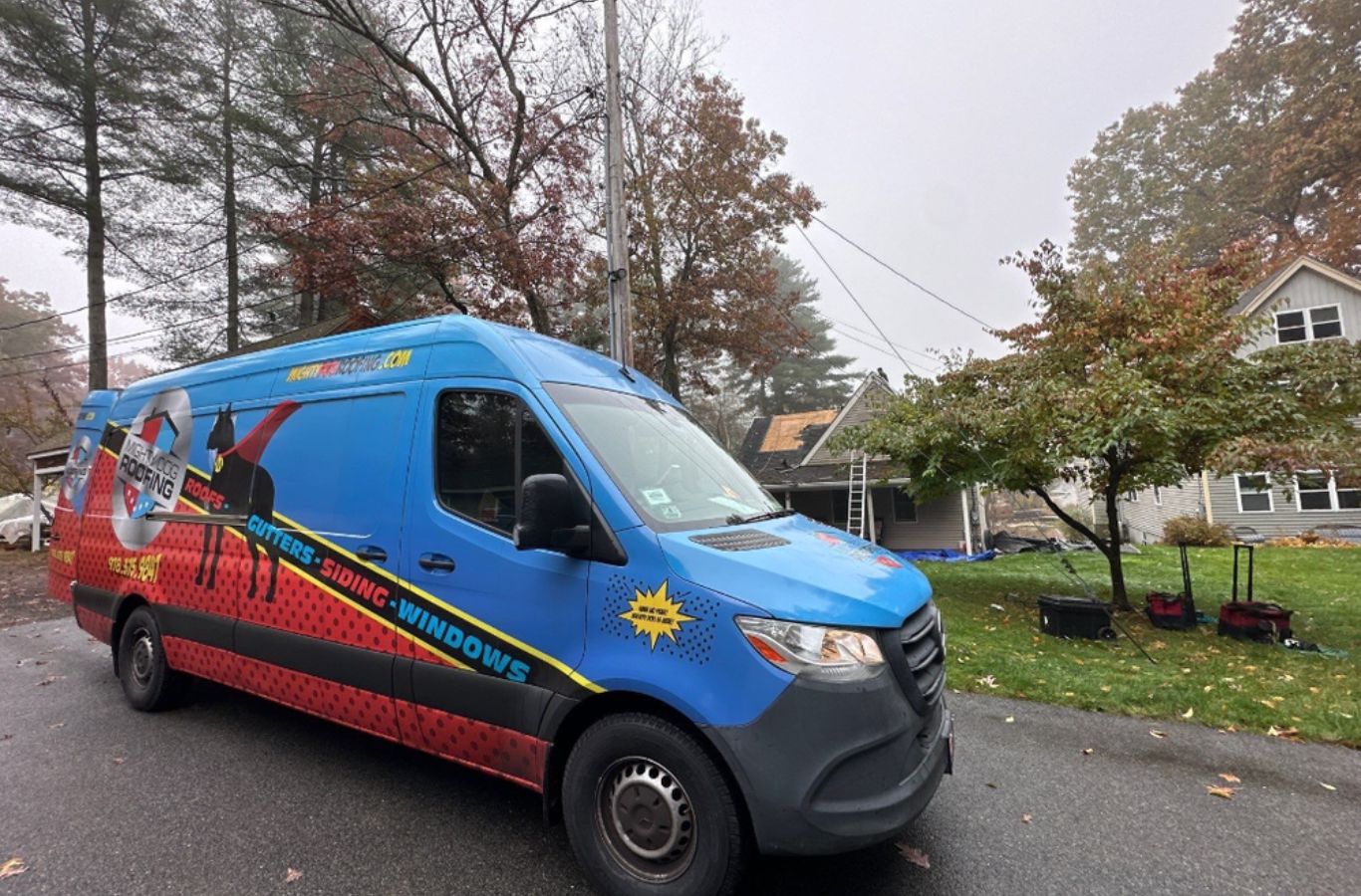 A Mighty Dog Roofing crew measuring and cutting seamless gutters in Concord, MA to prevent overflow and reduce maintenance.