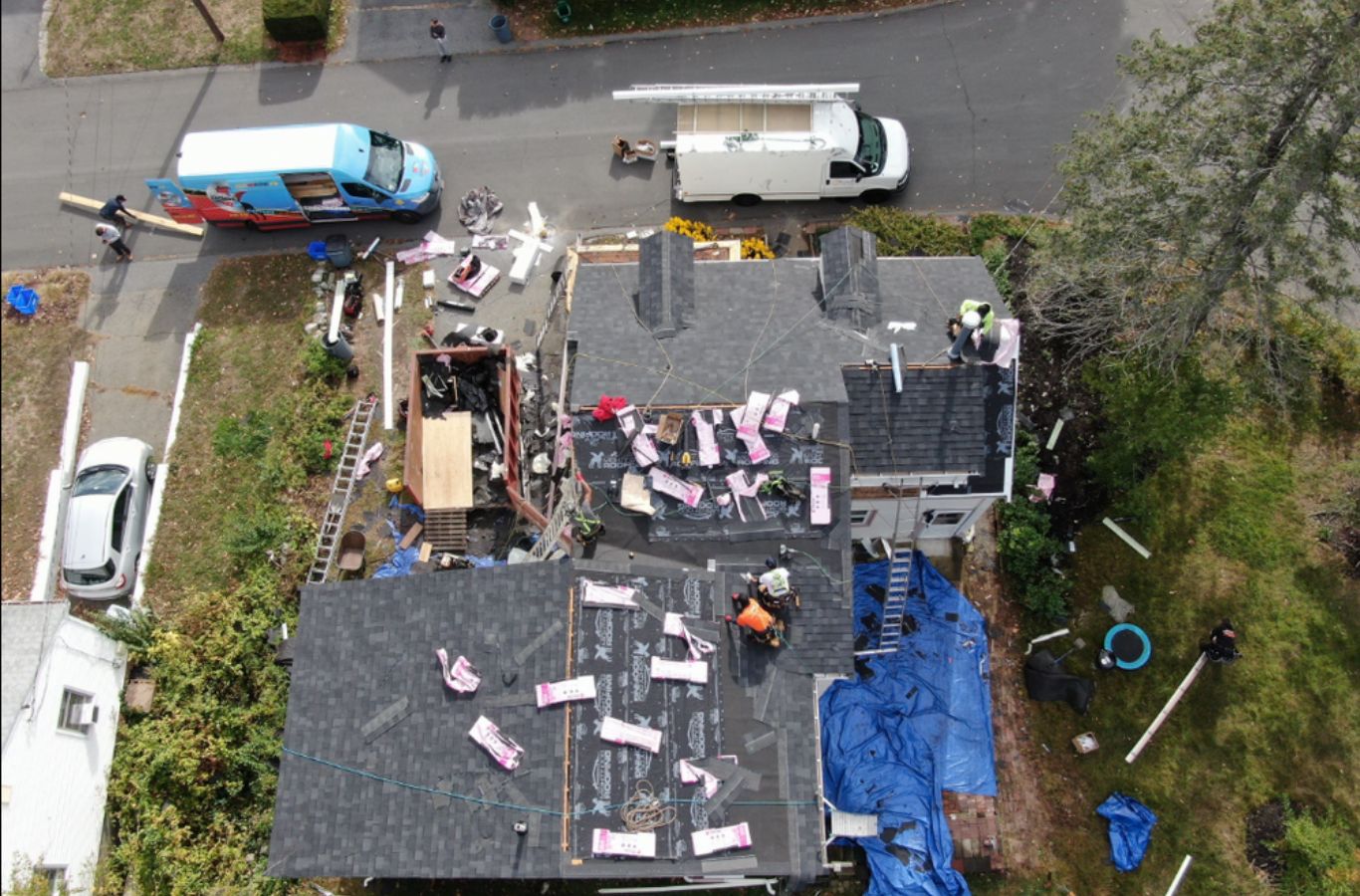 A Mighty Dog Roofing of Greater Middlesex County crew fixing shingles in Billerica, MA, highlighting attentive workmanship.