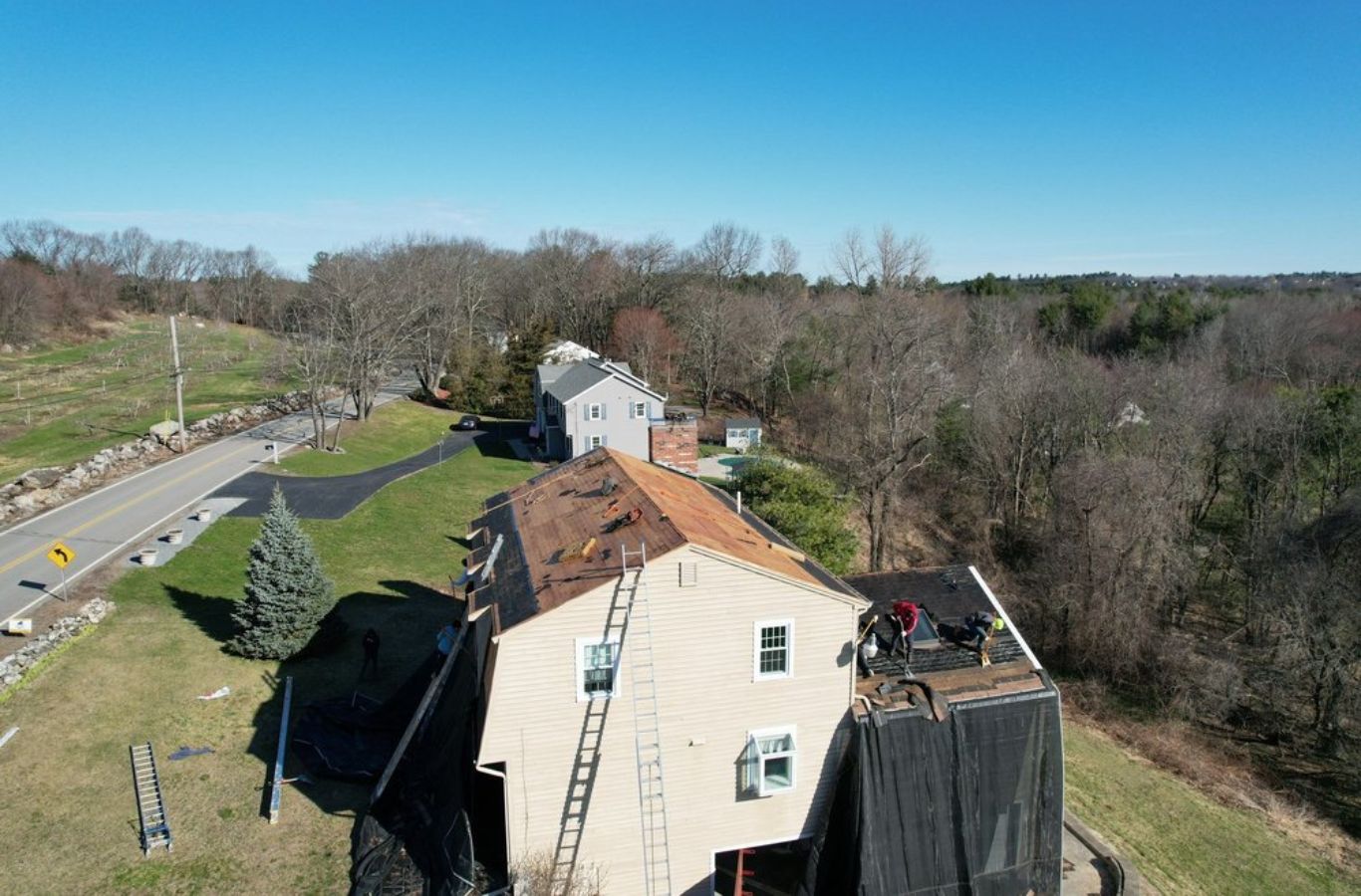 A Mighty Dog Roofing of Greater Middlesex County crew repairing roof shingles in Wilmington, MA, showcasing attention to detail.
