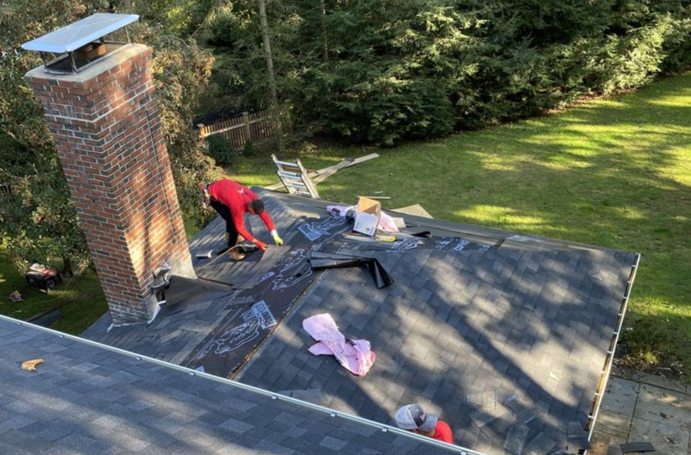 A Mighty Dog Roofing of Greater Middlesex County technician repairing roofing on a residential property in Arlington, MA, ensuring professional results.