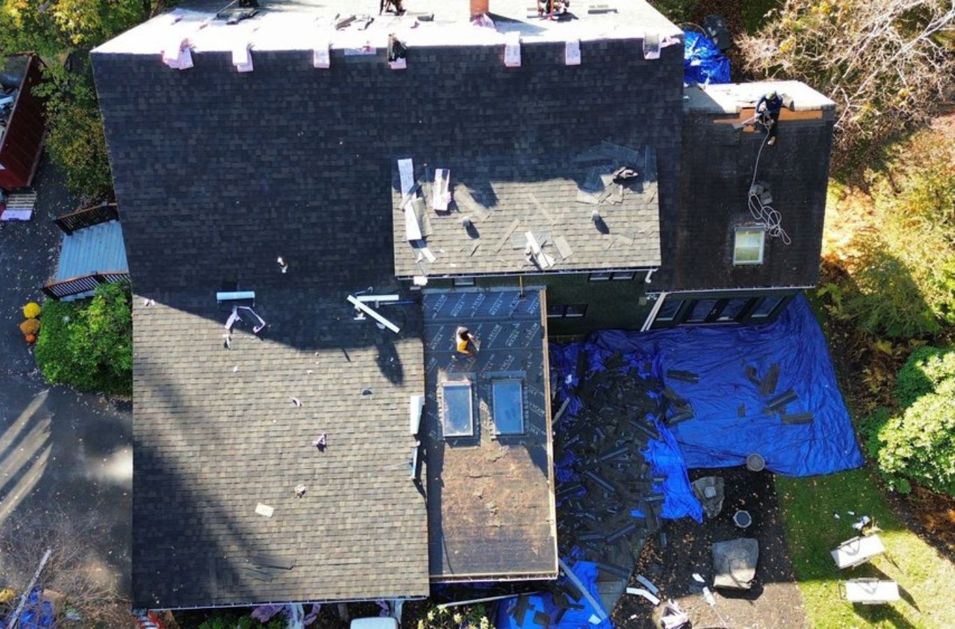 A Mighty Dog Roofing of Greater Middlesex County technician repairing a residential roof in Belmont, MA, ensuring precise and reliable results.