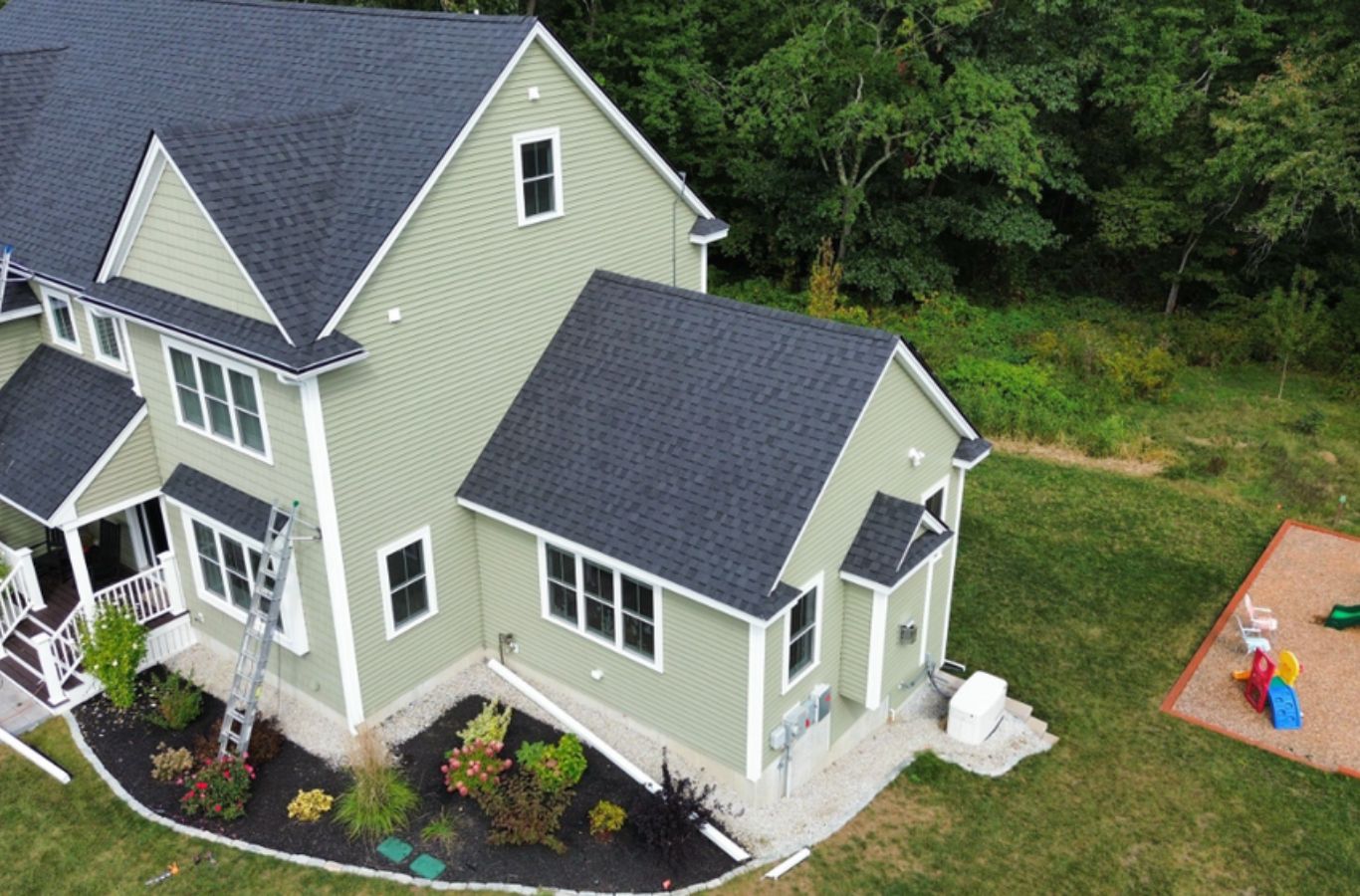 A Mighty Dog Roofing of Greater Middlesex County crew member applying new siding in Lowell, MA using durable materials and expert techniques.