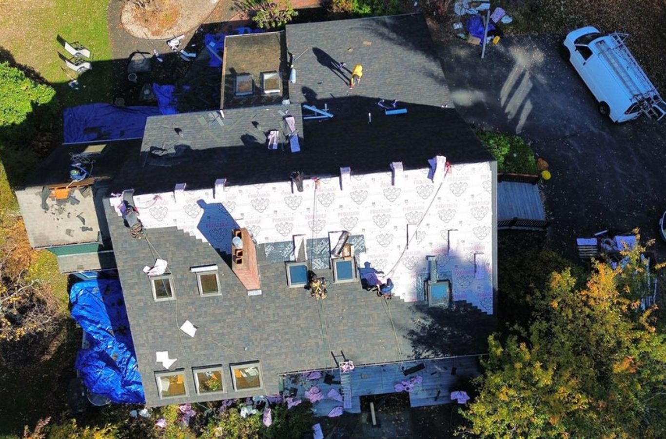 A Mighty Dog Roofing of Greater Middlesex County expert aligning roofing materials on a home in Bedford, MA, ensuring precise repair. Roof Repair near me.