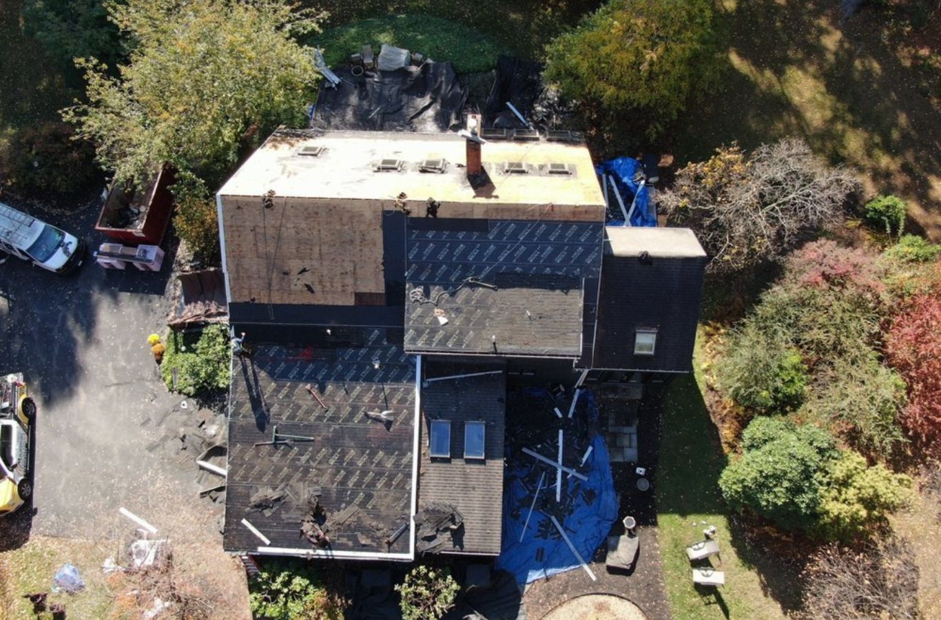 A Mighty Dog Roofing of Greater Middlesex County expert inspecting a damaged roof in Belmont, MA, showcasing quality-first repair. Roof Repair near me.