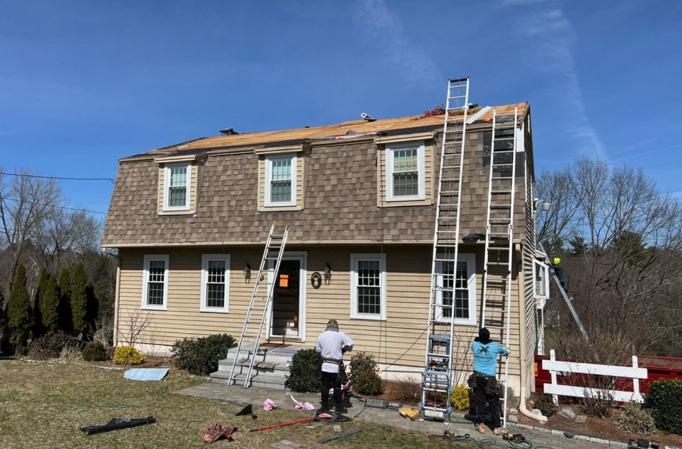 A Mighty Dog Roofing of Greater Middlesex County specialist inspecting a repaired roof in Wilmington, MA, ensuring long-term quality. Roof Repair near me.