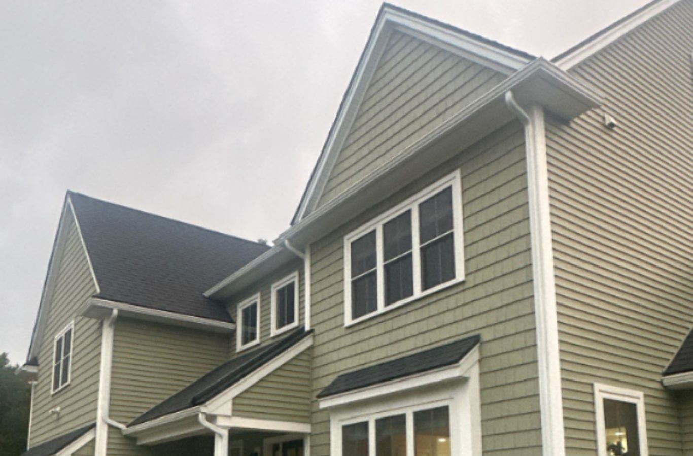 A Mighty Dog Roofing professional finalizing siding trim in Lowell, MA with clean workmanship and attention to detail on every panel. Siding Company near me.
