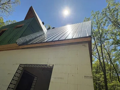 Metal roof with vertical panels on a residential home surrounded by trees in the Chattanooga area