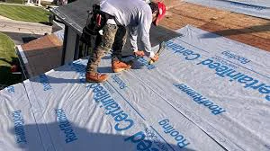 Roofing crew installing new underlayment and shingles during a full roof replacement on a Thornton, CO home