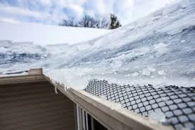 Ice dam formation along the eaves of a ranch-style home in Thornton, CO causing water backup under shingles