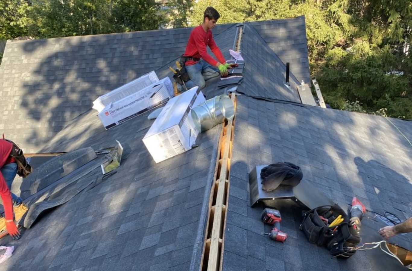 Roofing specialists from Mighty Dog Roofing securing new shingles in Dracut, MA, delivering reliable, high-performance roofing services.