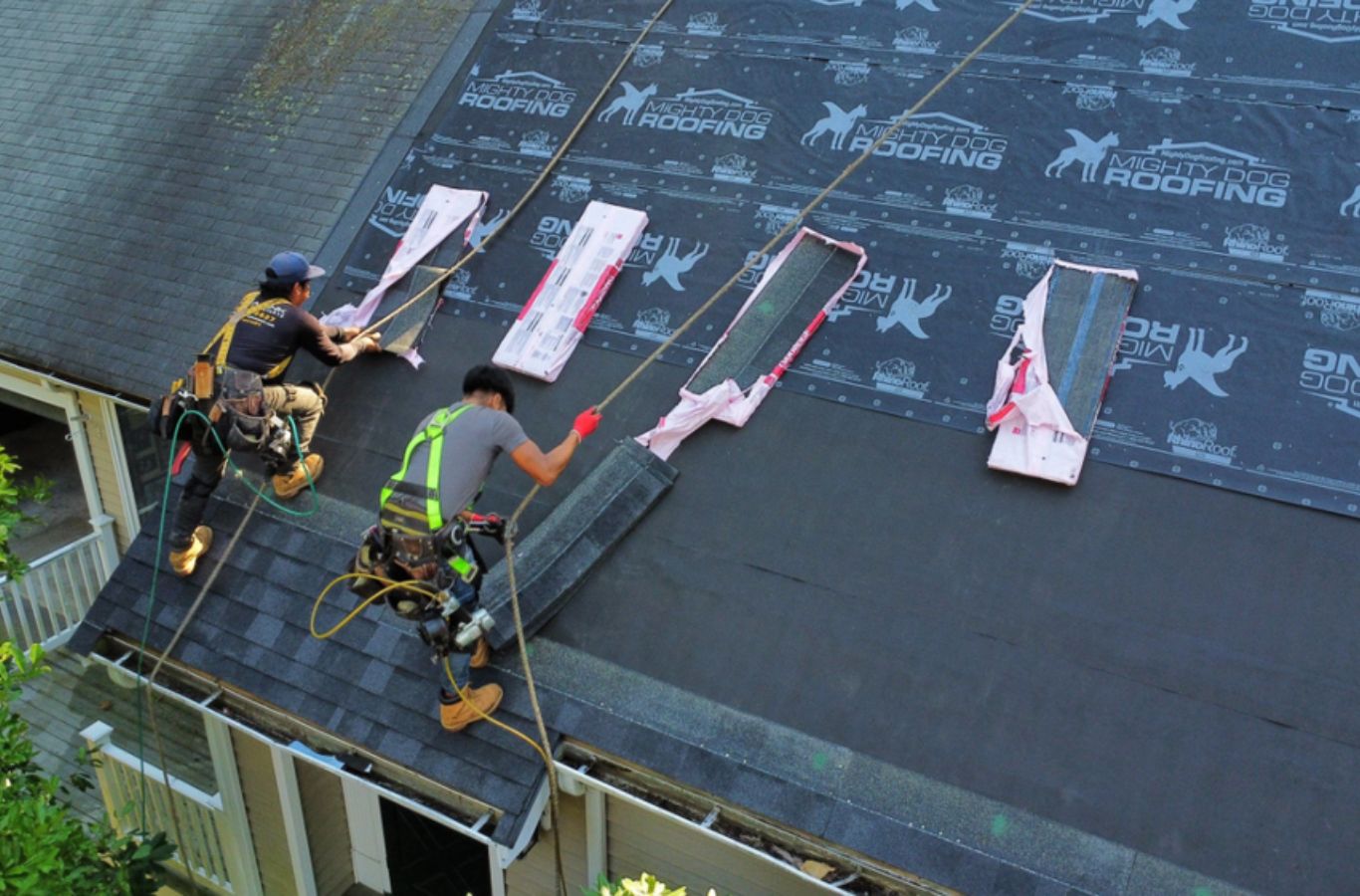 Technicians from Mighty Dog Roofing sealing a new roof system in Dracut, MA, roofing company near me.