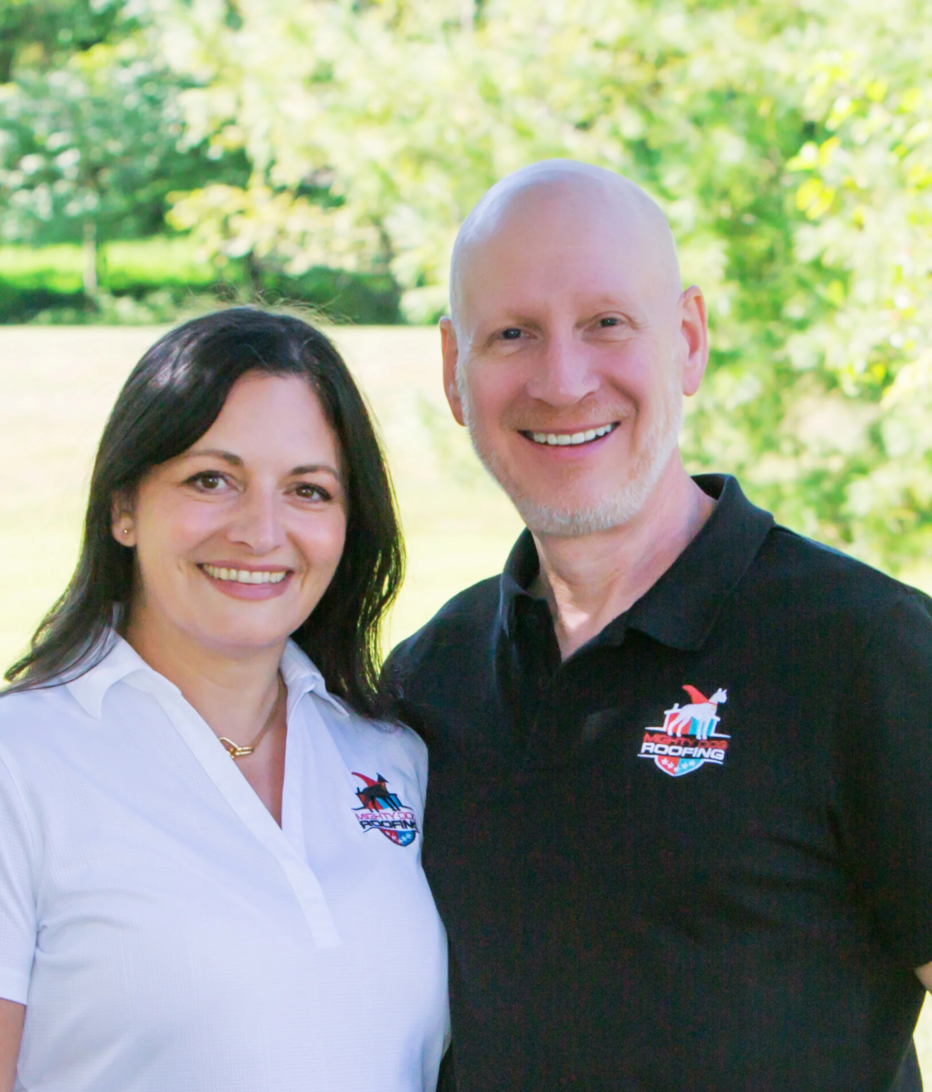 Erin and Jim standing next to each other in front of a leafy tree