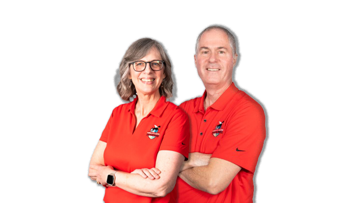 Man and woman in red shirts standing with arms crossed